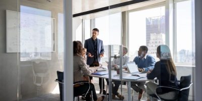 Successful Latin American business man talking to a group of people in a meeting a the office